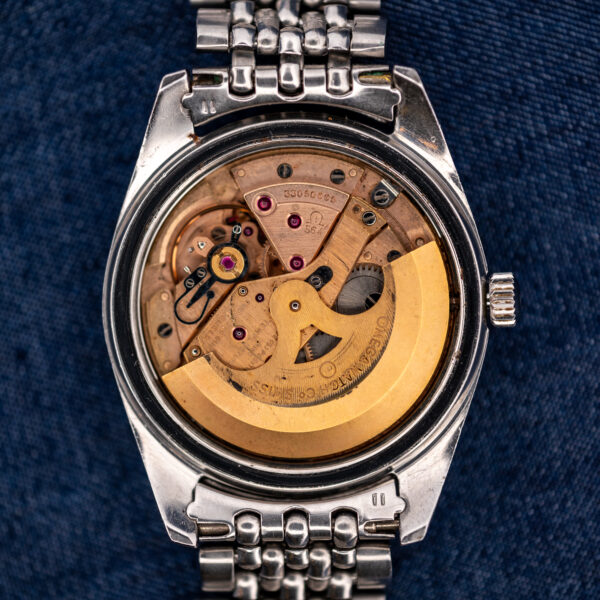 Omega 564 automatic movement inside opened Seamaster case, showing signed rotor, bridges and winding components