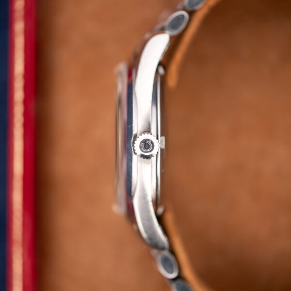 Omega Seamaster 166.010 side profile showing signed winding crown, raised crystal and curved stainless steel lugs