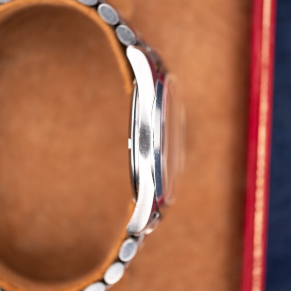 Omega Seamaster opposite case profile with raised crystal silhouette and stainless steel bracelet curving behind the lugs