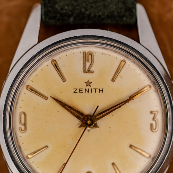 Zenith dial close-up showing star emblem, Arabic numerals and pointed hands above the minute track