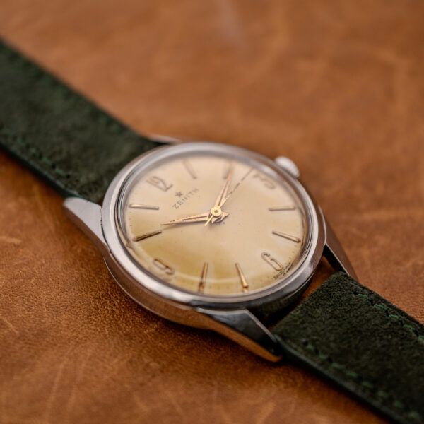 Zenith low diagonal portrait showing pointed hands, Arabic quarter-hour numerals and the adjacent suede strap