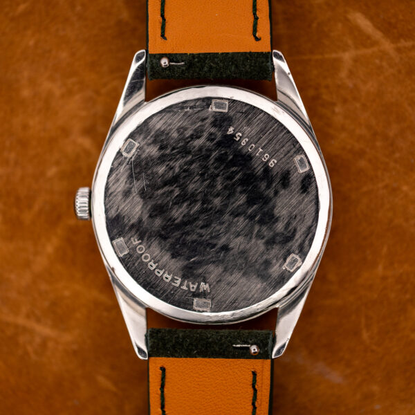 Zenith outer caseback showing stamped number, perimeter opening notches and engraved lettering around the center