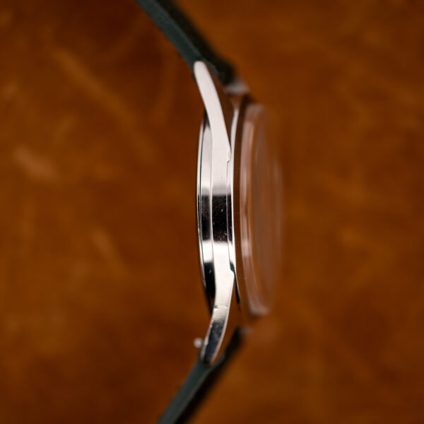 Zenith opposite side profile emphasizing curved lugs and raised crystal above the stainless steel case flank
