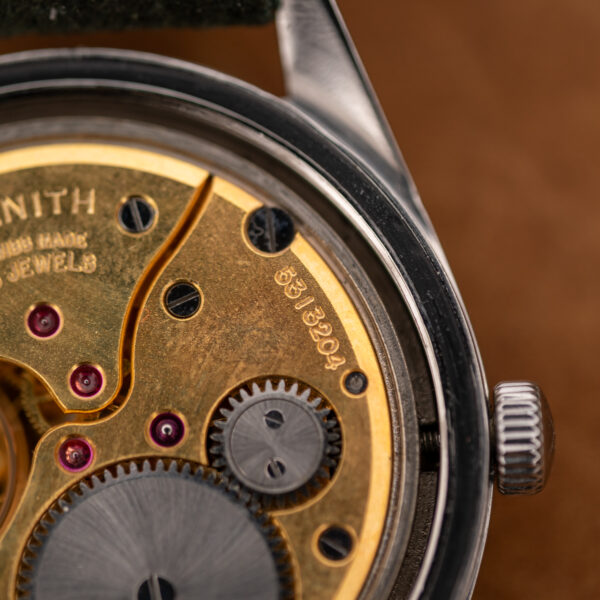 Zenith movement close-up showing stamped serial number, winding gear and part of the signed bridge
