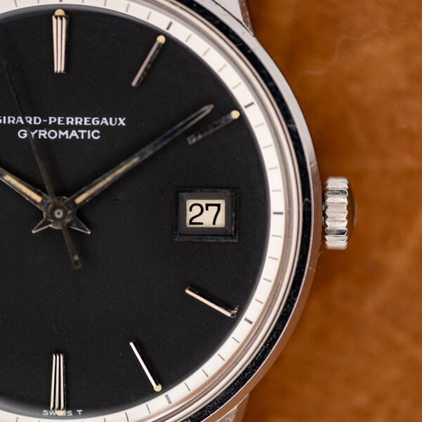 Girard Perregaux Gyromatic crown-side close-up with date window, white minute track and lower dial signature