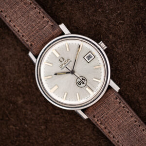 Omega automatic watch diagonal portrait with silver sunburst dial, circular USS emblem and framed date display