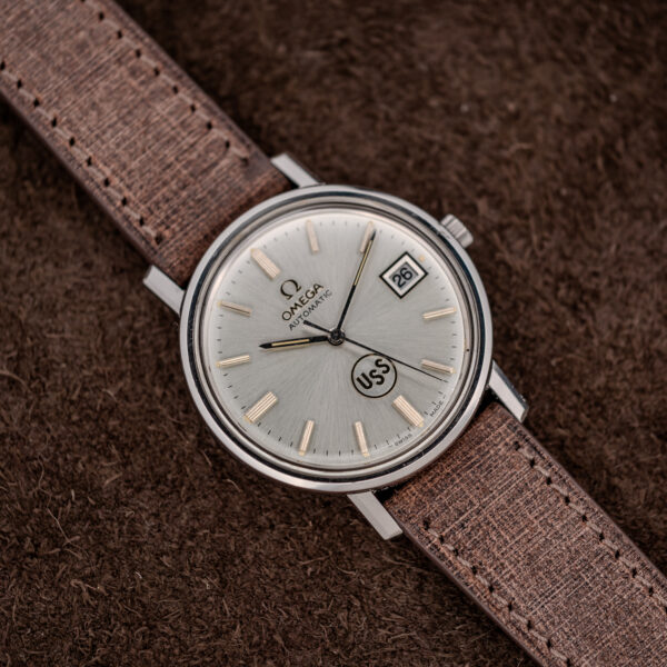 Omega automatic angled portrait with circular USS dial emblem, applied hour markers and framed date display