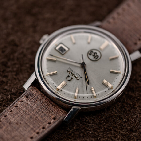 Omega automatic low inverted view highlighting applied Omega lettering, hour markers and the domed crystal edge