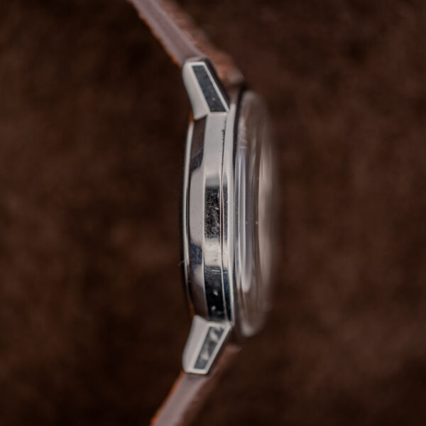 Omega automatic opposite side view showing curved lugs, case flank and raised crystal above the strap