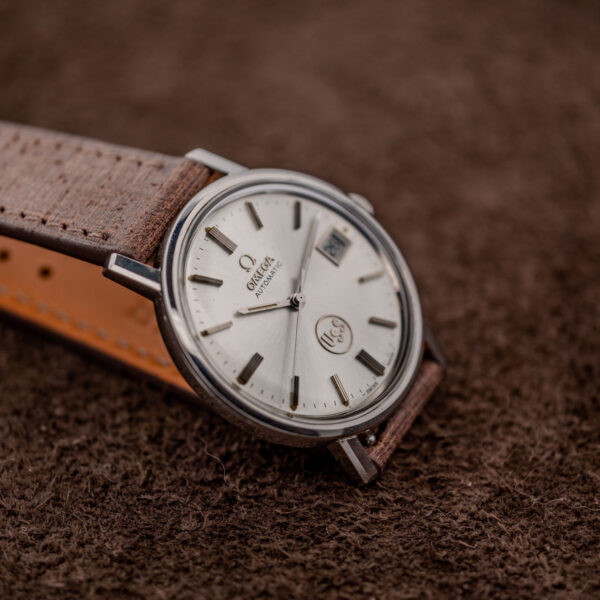 Omega automatic three-quarter side view showing sunburst dial, applied indices and strap curving behind the case