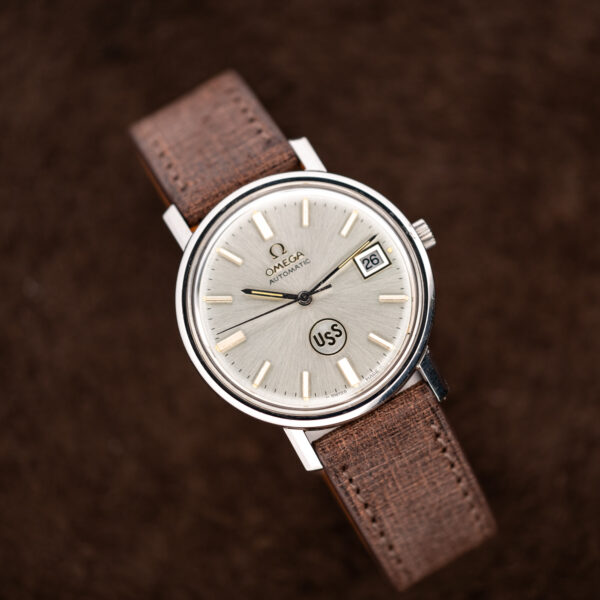 Omega automatic frontal portrait with sunburst dial, circular USS emblem and applied baton hour markers