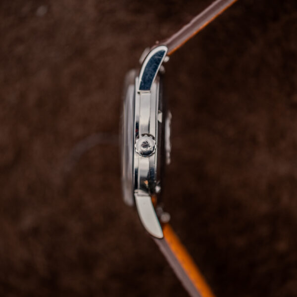 Omega Seamaster side profile showing signed winding crown, broad downturned lugs and raised crystal edge