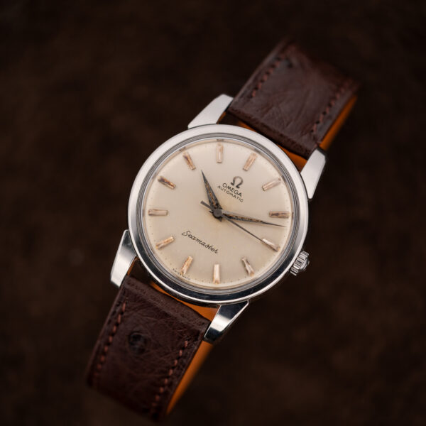 Omega Seamaster upright three-quarter portrait showing broad lugs and the looped ostrich strap beneath its case