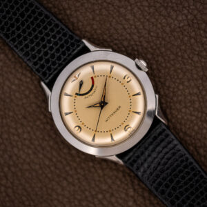 Wittnauer 2092 overhead view with cream dial, curved power reserve indicator and textured black strap