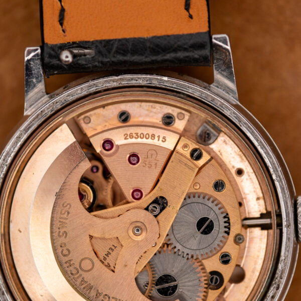 Close-up of the Omega caliber 551 movement showing the caliber number and serial 26300815