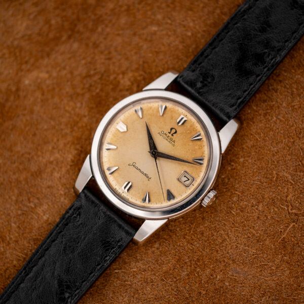 Full diagonal view of the vintage Omega Seamaster with amber outer dial and textured black strap