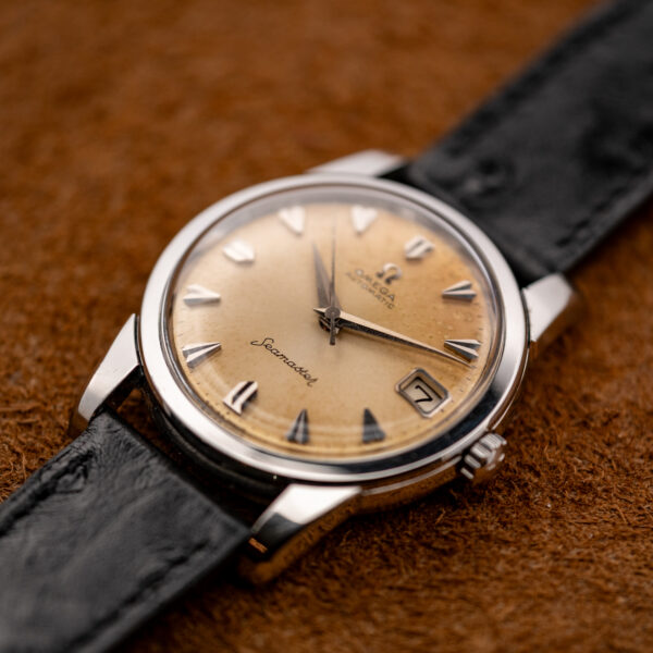 Low crown-side view of the Omega Seamaster showing the date aperture, signed crown and domed crystal