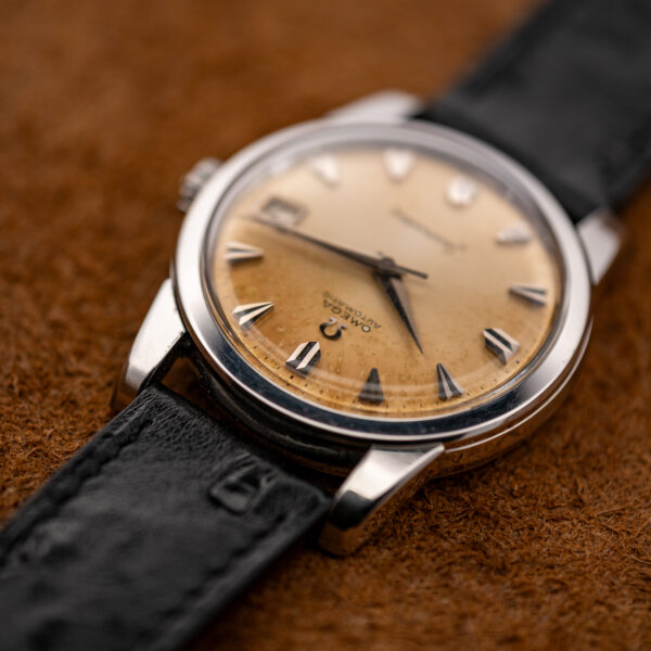 Inverted oblique view of the Seamaster 166.009 showing the amber dial perimeter, upper lugs and crystal