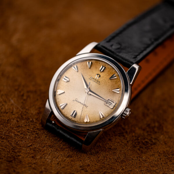 Opposite oblique view of the vintage Omega Seamaster showing the date dial, straight lugs and black strap