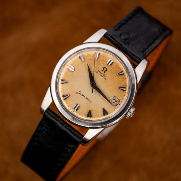 Three-quarter view of the Seamaster 166.009 with faceted markers and the black strap curved into a loop