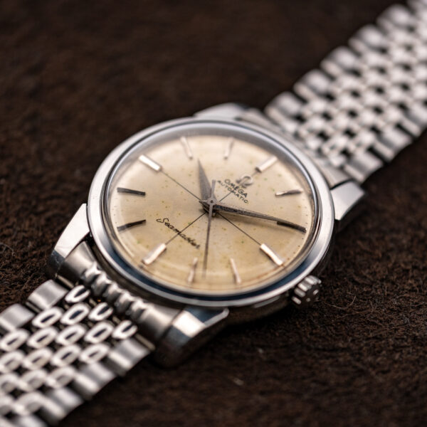 Low crown-side view of the 1961 Omega Seamaster with crosshair dial, signed crown and bracelet links