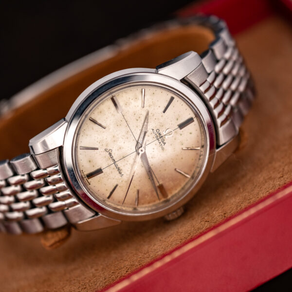 Omega Seamaster 14761 on a display support, off-white crosshair dial and steel bracelet facing forward