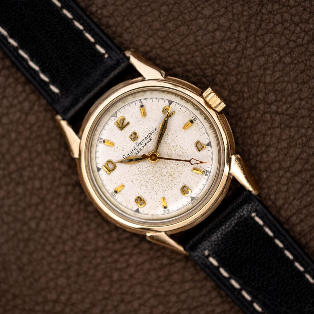 Girard Perregaux Sea Hawk B-1801 overhead view with speckled dial, applied numerals and stitched black strap