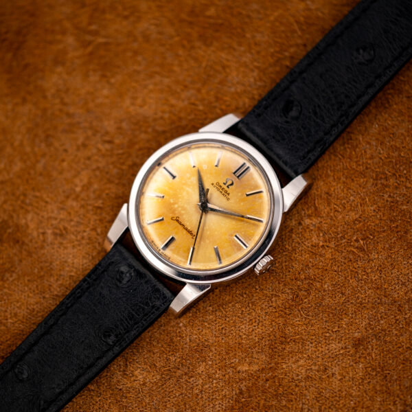 Full diagonal view of the Omega Seamaster 14761 amber dial on its black textured strap