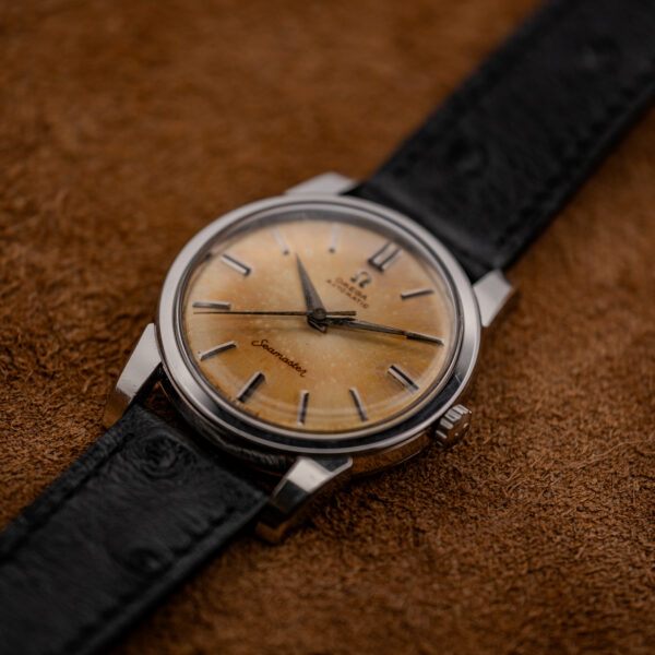 Crown-side low view of the Omega Seamaster 14761 with amber dial, case profile and black strap