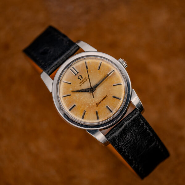 Omega Seamaster 14761 three-quarter view from the other side, showing amber dial and black-inlaid batons