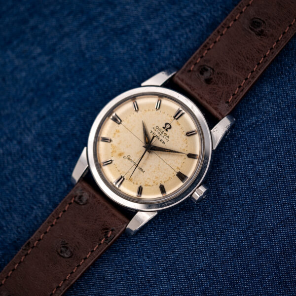 Diagonal front view of the crosshair Omega Seamaster on a stitched chocolate-brown ostrich strap