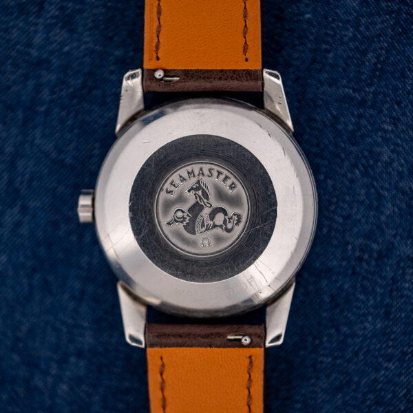 Omega Seamaster caseback with seahorse medallion and Seamaster engraving above the brown strap underside