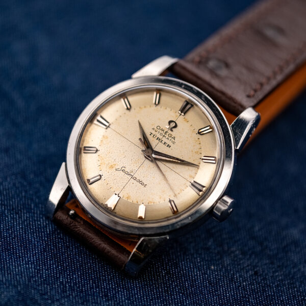 Bright three-quarter front of the Omega Seamaster showing the Türler dial, crosshair and stainless steel case