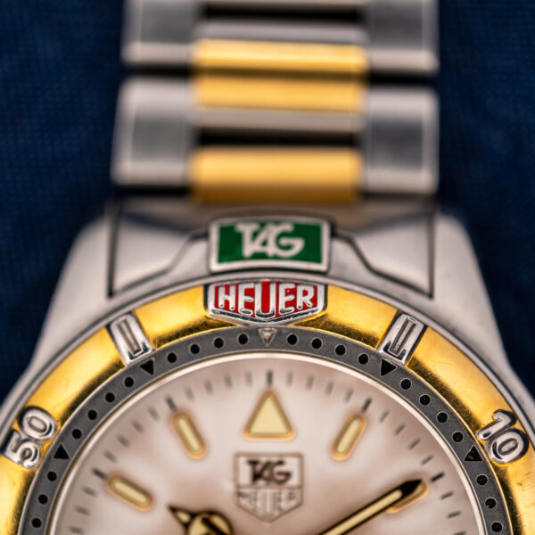 Close-up of the split green-and-red TAG Heuer shield across the case and bezel of the 995.706 K