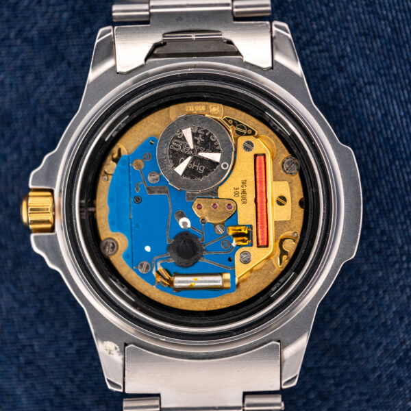 Open caseback of the TAG Heuer 995.706 K revealing the quartz movement, battery and blue circuit plate