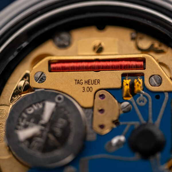 Close-up of the TAG Heuer 3.00 quartz movement bridge and red coil inside the 995.706 K