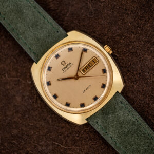 Omega De Ville 166.053 from a diagonal angle, champagne day-date dial and cushion case on green suede strap
