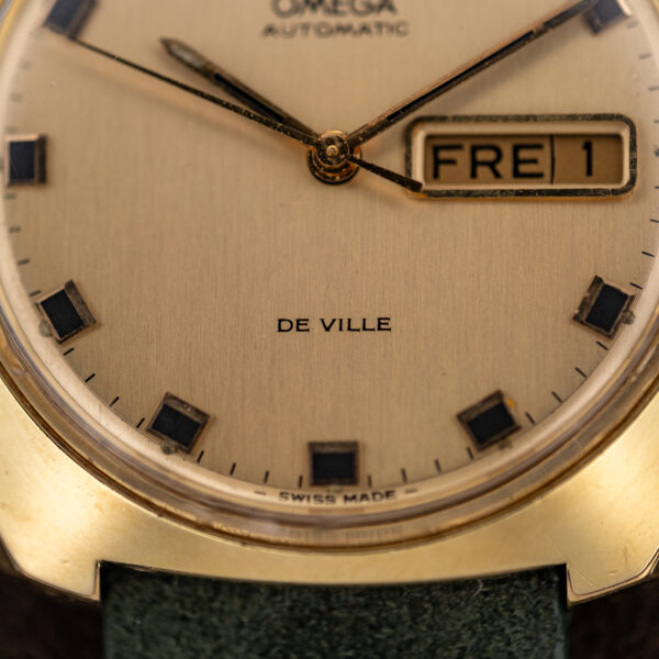 Lower dial close-up of Omega 166.053 with De Ville and Swiss Made text and black-centered square markers