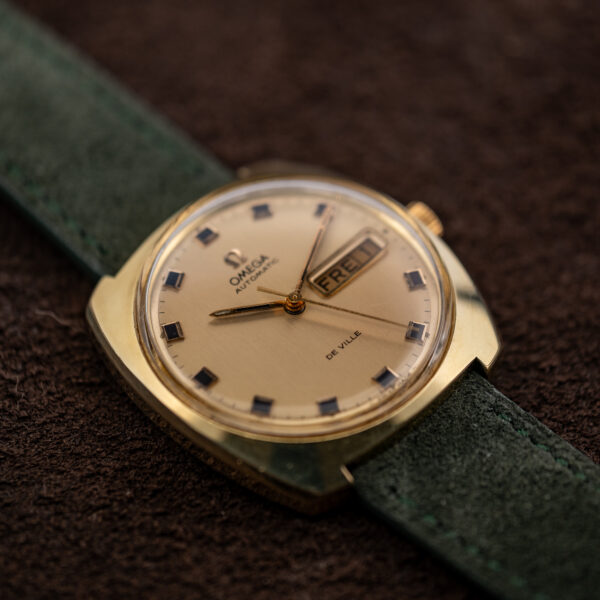Low angle from the left of the Omega De Ville 166.053 cushion case, dial and green strap
