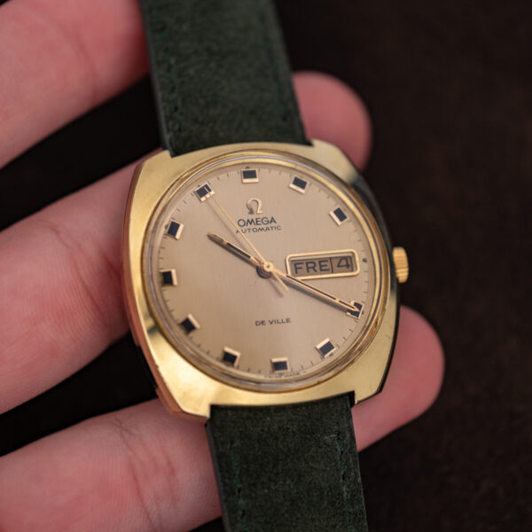 Omega De Ville 166.053 held in hand, champagne dial reading FRE 4 in the day-date window