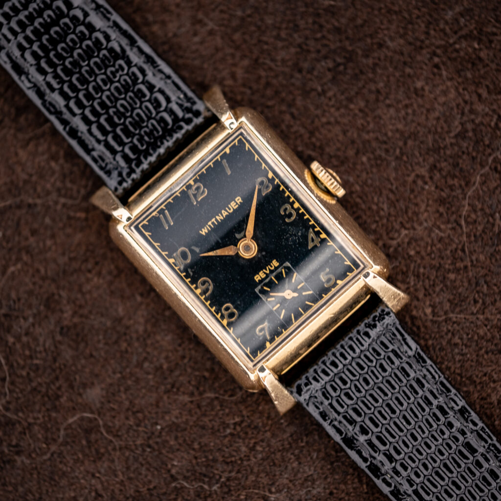 Wittnauer Revue seen diagonally, black Art Deco dial with gold-toned Arabic numerals and square small seconds