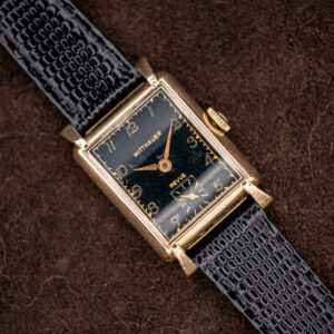 Wittnauer Revue seen diagonally, black Art Deco dial with gold-toned Arabic numerals and square small seconds