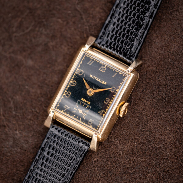 Wide angled view of the Wittnauer Revue rectangular gold-filled watch on its black textured leather strap