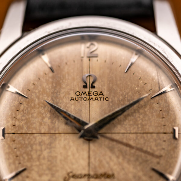 Upper dial close-up of the Omega Seamaster showing applied Arabic twelve, Omega logo and Automatic text