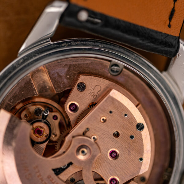Close-up of the Omega caliber 500 stamp and balance area on the copper-toned movement