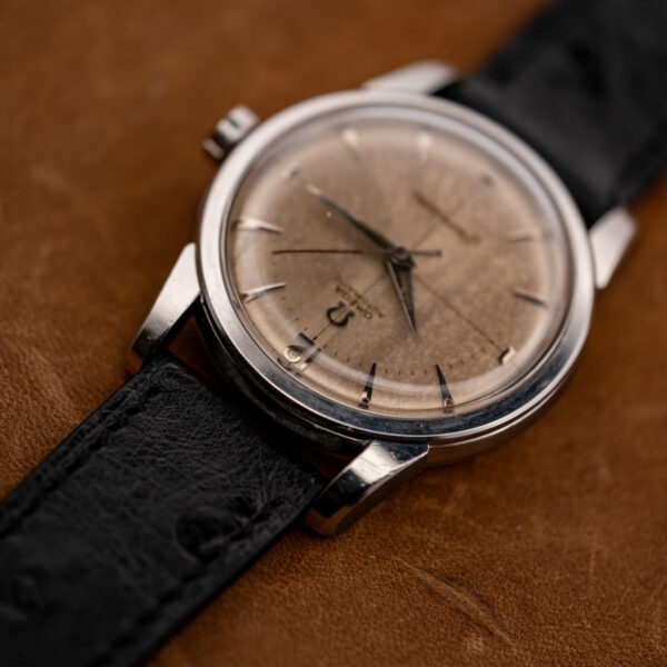 Low view from twelve o'clock of the Omega Seamaster showing the domed crystal and Arabic numeral