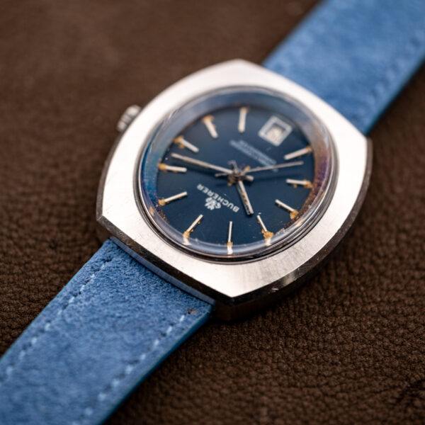 Low side angle of the Bucherer 1574 showing the raised crystal above the case and blue suede strap