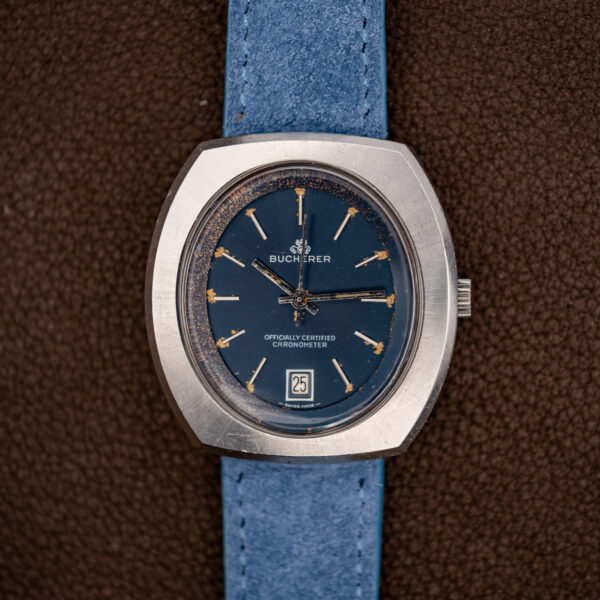 Straight-on view of the Bucherer 1574 blue chronometer dial with baton markers and date at six