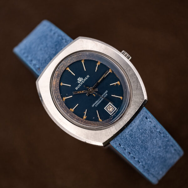 Bucherer 1574 on a stand at an angle, oval dial opening, date at six and blue strap