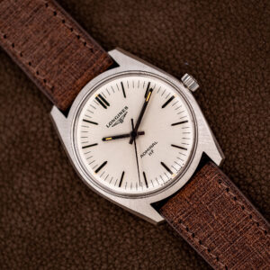 Longines Admiral HF 2301-4 at an angle: white radial dial, pointed baton hands, angular brushed steel case, brown strap